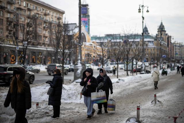 People carry shopping bags in central in Kyiv on February 18, 2026, amid the Russian invasion of Ukraine. (Photo by HENRY NICHOLLS / AFP)