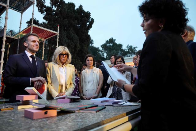 France's President Emmanuel Macron (L) with his wife Brigitte Macron (2L) listens to poetry during a discussion at the French Institute in New Delhi on February 18, 2026. (Photo by Ludovic MARIN / AFP)