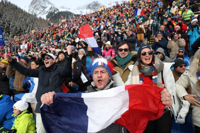 A fan waves France's flag while watching the women's biathlon 4x6km relay event during the Milano Cortina 2026 Winter Olympic Games at the Anterselva Biathlon Arena (Sudtirol Arena) in Anterselva (Val Pusteria) on February 18, 2026. (Photo by Odd ANDERSEN / AFP)