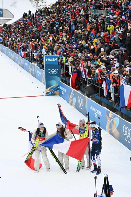 France's Camille Bened, Lou Jeanmonnot, Oceane Michelon and Julia Simon celebrate after winning gold in the women's biathlon 4x6km relay event during the Milano Cortina 2026 Winter Olympic Games at the Anterselva Biathlon Arena (Sudtirol Arena) in Anterselva (Val Pusteria) on February 18, 2026. (Photo by François-Xavier MARIT / AFP)