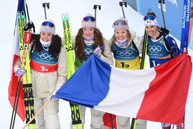 France's Camille Bened, Lou Jeanmonnot, Oceane Michelon and Julia Simon celebrate after winning gold in the women's biathlon 4x6km relay event during the Milano Cortina 2026 Winter Olympic Games at the Anterselva Biathlon Arena (Sudtirol Arena) in Anterselva (Val Pusteria) on February 18, 2026. (Photo by François-Xavier MARIT / AFP)