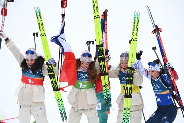 France's Camille Bened, Lou Jeanmonnot, Oceane Michelon and Julia Simon celebrate after winning gold in the women's biathlon 4x6km relay event during the Milano Cortina 2026 Winter Olympic Games at the Anterselva Biathlon Arena (Sudtirol Arena) in Anterselva (Val Pusteria) on February 18, 2026. (Photo by François-Xavier MARIT / AFP)