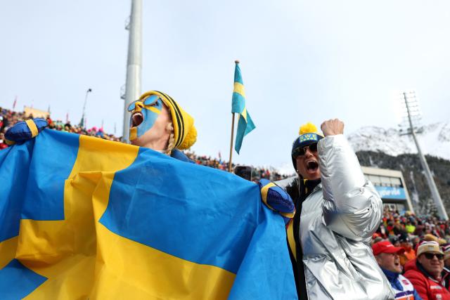 A fan waves Sweden's flag while watching the women's biathlon 4x6km relay event during the Milano Cortina 2026 Winter Olympic Games at the Anterselva Biathlon Arena (Sudtirol Arena) in Anterselva (Val Pusteria) on February 18, 2026. (Photo by Odd ANDERSEN / AFP)