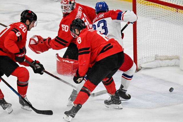 Czech Republic's #23 Lukas Sedlak (rear R) shoots and scores his team's first goal during the men's play-off quarter-final ice hockey match between Canada and Czech Republic at the Milano Santagiulia Ice Hockey Arena during the Milano Cortina 2026 Winter Olympic Games in Milan, on February 18, 2026. (Photo by Alexander NEMENOV / AFP)