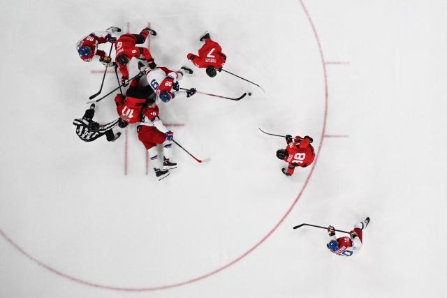 Canada's #10 Nick Suzuki falls over Czech Republic's #48 Tomas Hertl during the men's play-off quarter-final ice hockey match between Canada and Czech Republic at the Milano Santagiulia Ice Hockey Arena during the Milano Cortina 2026 Winter Olympic Games in Milan, on February 18, 2026. (Photo by Alexander NEMENOV / AFP)