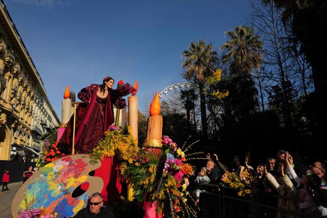 An artist performs before members of the public during the Flower parade, as part the 141st edition of the Nice Carnival in the French Riviera City of Nice on February 18, 2026. The edition 2026 of the Carnival called "Long live the Queen! will take place until March 1, 2026. (Photo by Valery HACHE / AFP)