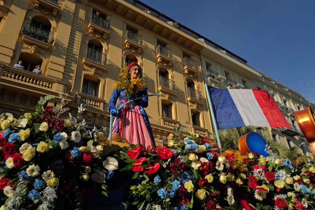 An artist performs before members of the public during the Flower parade, as part the 141st edition of the Nice Carnival in the French Riviera City of Nice on February 18, 2026. The edition 2026 of the Carnival called "Long live the Queen! will take place until March 1, 2026. (Photo by Valery HACHE / AFP)