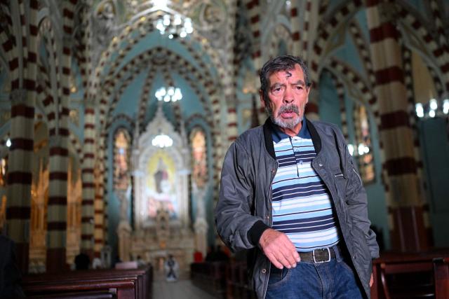 A man is seen after receiving the sign of the cross in ashes on her forehead from a priest during Ash Wednesday celebrations at Santuario El Carmen in Bogota on February 18, 2026. Ash Wednesday marks the Christian period of Lent, prior to the Holy Week. (Photo by Luis ACOSTA / AFP)