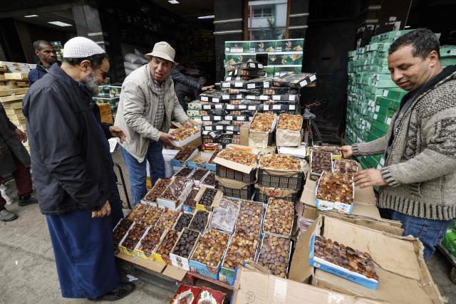 Men arrange boxes of dates at a stall in a wholesale market in Casablanca on February 18, 2026, ahead of the start of the holy fasting month of Ramadan. (Photo by Abdel Majid BZIOUAT / AFP)