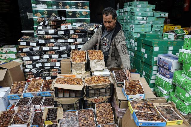A man arranges boxes of dates at a stall in a wholesale market in Casablanca on February 18, 2026, ahead of the start of the holy fasting month of Ramadan. (Photo by Abdel Majid BZIOUAT / AFP)