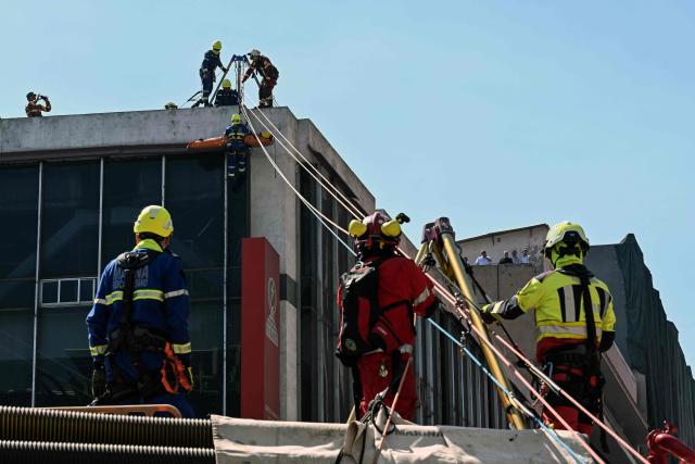 Members of government rescue institutions aid a participant during an earthquake drill in Mexico City on February 18, 2026. (Photo by Yuri CORTEZ / AFP)