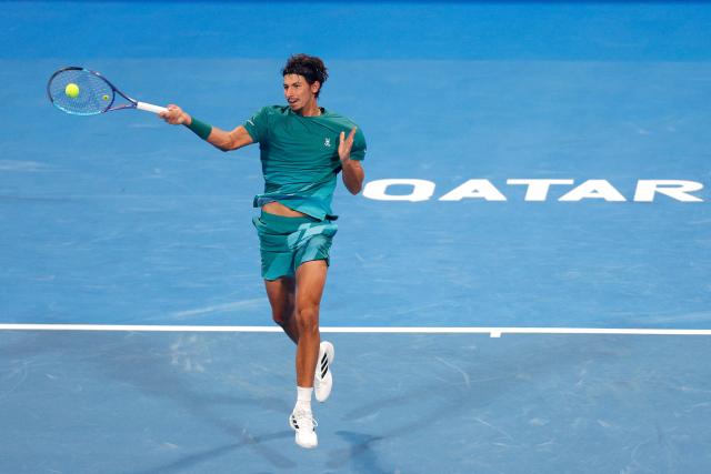 Australia's Alexei Popyrin hits a return against Italy's Jannik Sinner during their men’s singles match at the Qatar Open tennis tournament in Doha on February 18, 2026. (Photo by Karim JAAFAR / AFP)