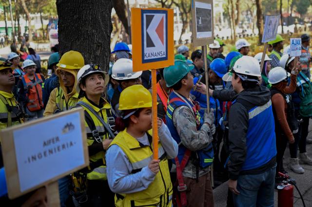 Construction workers take part in an earthquake drill in Mexico City on February 18, 2026. (Photo by Alfredo ESTRELLA / AFP)