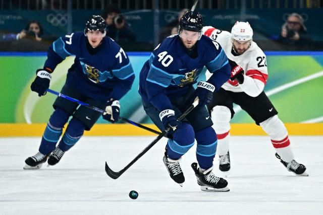 (From L) Finland's #77 Niko Mikkola, Finland's #40 Joel Armia and Switzerland's #22 Nino Niederreiter vie for the puck during the men's play-off quarter-final ice hockey match between Finland and Switzerland at the Milano Rho Ice Hockey Arena during the Milano Cortina 2026 Winter Olympic Games in Milan, on February 18, 2026. (Photo by JULIEN DE ROSA / AFP)