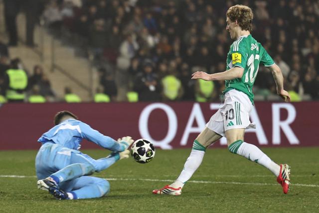 Qarabag's Polish goalkeeper #99 Mateusz Kochalski in action with Newcastle United's English midfielder #10 Anthony Gordon during the UEFA Champions League knockout phase play-off first leg football match between Qarabag and Newcastle at the Tofiq Bahramov Republican Stadium in Baku on February 18, 2026. (Photo by Giorgi ARJEVANIDZE / AFP)