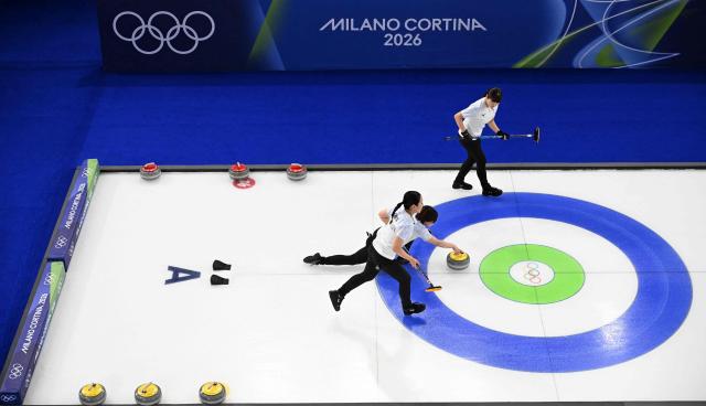 Japan's Anna Ohmiya and Japan's Sayaka Yoshimura compete in the curling women's round robin between Britain and Japan during the Milano Cortina 2026 Winter Olympic Games at the Cortina Curling Olympic Stadium in Cortina d’Ampezzo on February 18, 2026. (Photo by Wikus de WET / AFP)