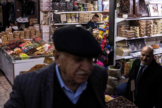 Vendors sell sweets in Jerusalem's Old City ahead of the breaking of the fast at the end of the first day of the holy month of Ramadan on February 18, 2026. (Photo by JOHN WESSELS / AFP)