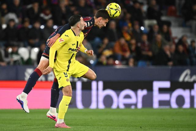 Villarreal's French forward #09 Georges Mikautadze (L) and Levante's Argentine defender #02 Matias Agustin Moreno vie for a header during the Spanish league football match between Levante UD and Villarreal CF at Ciutat de Valencia Stadium in Valencia on February 18, 2026. (Photo by JOSE JORDAN / AFP)