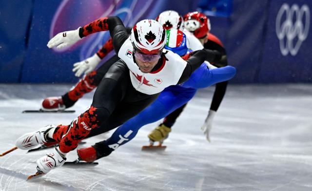 Canada's William Dandjinou leads the pack during the short track speed skating men's 500m quarter-final during the Milano Cortina 2026 Winter Olympic Games at Milano Ice Skating Arena in Milan on February 18, 2026. (Photo by WANG Zhao / AFP)