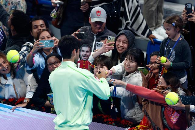 Spain's Carlos Alcaraz sign autographs with fans after his men’s singles match victory over France's Valentin Royer at the Qatar Open tennis tournament in Doha on February 18, 2026. (Photo by Karim JAAFAR / AFP)