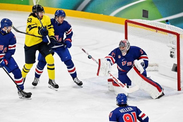 USA's goalkeeper #37 Connor Hellebuyck (R) makes a save during the men's play-off quarter-final ice hockey match between USA and Sweden at the Milano Santagiulia Ice Hockey Arena during the Milano Cortina 2026 Winter Olympic Games in Milan, on February 18, 2026. (Photo by Alexander NEMENOV / AFP)