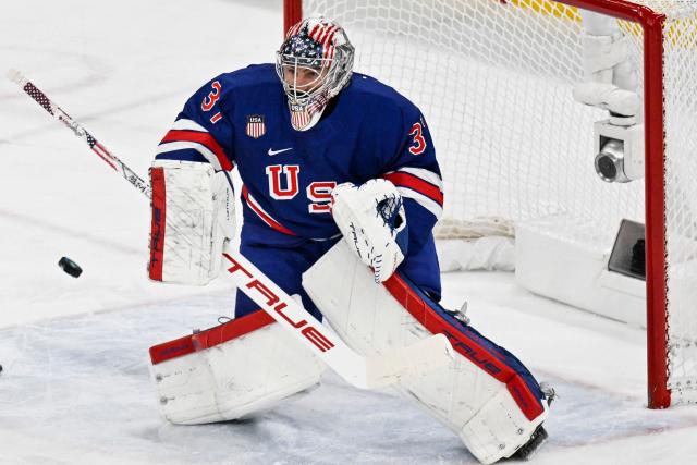 USA's goalkeeper #37 Connor Hellebuyck (R) makes a save during the men's play-off quarter-final ice hockey match between USA and Sweden at the Milano Santagiulia Ice Hockey Arena during the Milano Cortina 2026 Winter Olympic Games in Milan, on February 18, 2026. (Photo by Alexander NEMENOV / AFP)