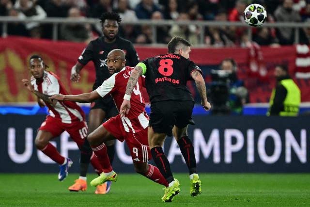 Olympiakos' Moroccan forward #09 Ayoub Kaabi (CL) and Bayer Leverkusen's German midfielder #08 Robert Andrich (R) fight for the ball during the UEFA Champions League knockout round play-off first leg football match between Olympiacos FC (GRE) and Bayer Leverkusen (GER) at the Karaiskakis Stadium in Piraeus, near Athens, on February 18, 2026. (Photo by Angelos Tzortzinis / AFP)