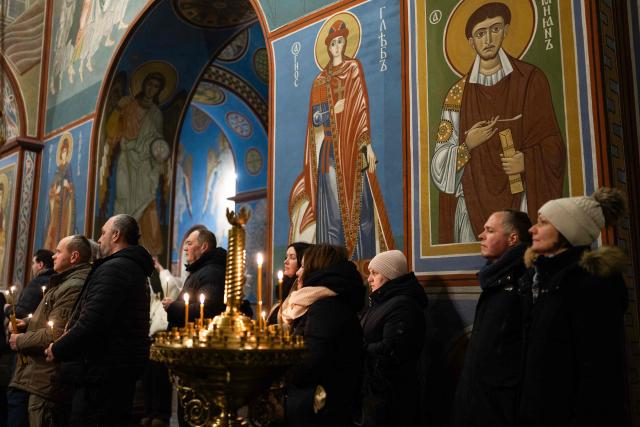 People attend a Day of the Heavenly Heroes memorial service at the St. Michael’s Golden-Domed Cathedral, honouring those killed during the mass Euromaidan protests Verkhovna Rada of Ukraine on February 18, 2014 in Kyiv on February 18, 2026, amid the Russian invasion of Ukraine. (Photo by HENRY NICHOLLS / AFP)