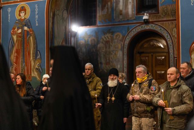 People attend a Day of the Heavenly Heroes memorial service at the St. Michael’s Golden-Domed Cathedral, honouring those killed during the mass Euromaidan protests Verkhovna Rada of Ukraine on February 18, 2014 in Kyiv on February 18, 2026, amid the Russian invasion of Ukraine. (Photo by HENRY NICHOLLS / AFP)