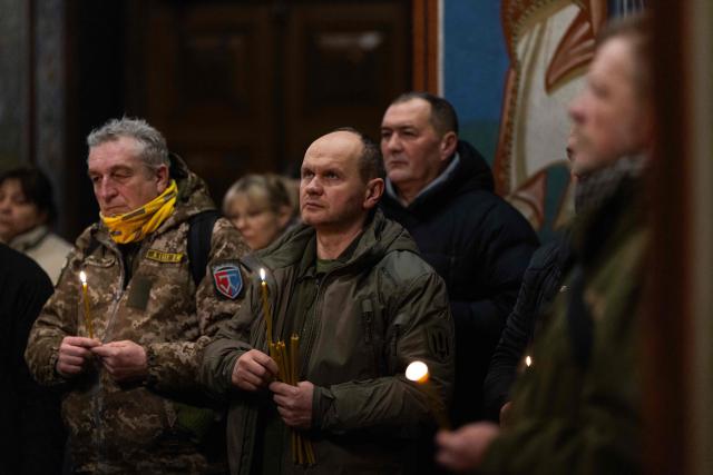 People attend a Day of the Heavenly Heroes memorial service at the St. Michael’s Golden-Domed Cathedral, honouring those killed during the mass Euromaidan protests Verkhovna Rada of Ukraine on February 18, 2014 in Kyiv on February 18, 2026, amid the Russian invasion of Ukraine. (Photo by HENRY NICHOLLS / AFP)