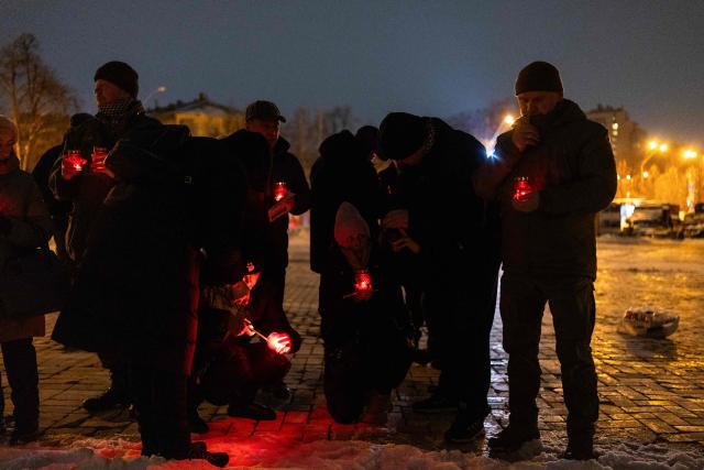 People pay respects at the Wall of Remembrance following the Day of the Heavenly Heroes memorial service at the St. Michael’s Golden-Domed Cathedral, honouring those killed during the mass Euromaidan protests Verkhovna Rada of Ukraine on February 18, 2014 in Kyiv on February 18, 2026, amid the Russian invasion of Ukraine. (Photo by HENRY NICHOLLS / AFP)