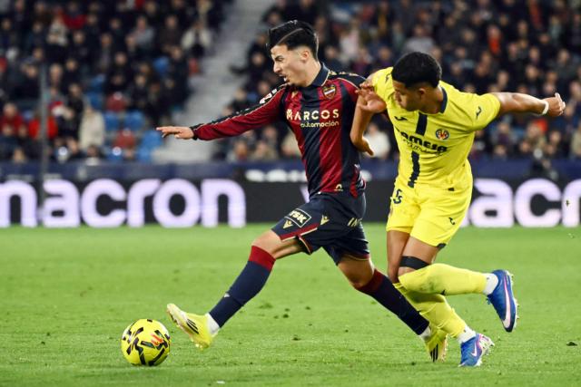 Levante's Spanish defender #27 Paco Cortes and Villarreal's Uruguayan defender #15 Santiago Mourino (R) fight for the ball during the Spanish league football match between Levante UD and Villarreal CF at Ciutat de Valencia Stadium in Valencia on February 18, 2026. (Photo by JOSE JORDAN / AFP)