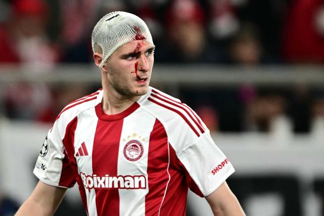 Olympiakos' Italian defender #05 Lorenzo Pirola bleeds from his head bandage during the UEFA Champions League knockout round play-off first leg football match between Olympiacos FC (GRE) and Bayer Leverkusen (GER) at the Karaiskakis Stadium in Piraeus, near Athens, on February 18, 2026. (Photo by Angelos Tzortzinis / AFP)