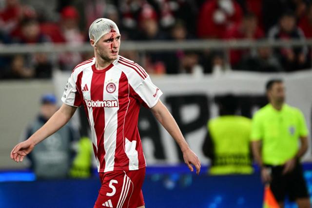 Olympiakos' Italian defender #05 Lorenzo Pirola bleeds from his head bandage during the UEFA Champions League knockout round play-off first leg football match between Olympiacos FC (GRE) and Bayer Leverkusen (GER) at the Karaiskakis Stadium in Piraeus, near Athens, on February 18, 2026. (Photo by Angelos Tzortzinis / AFP)