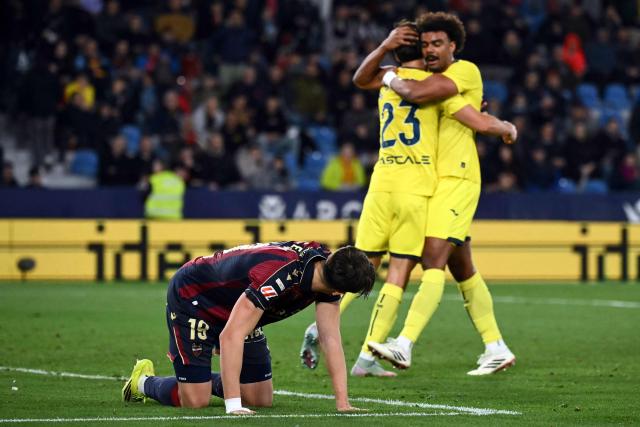 Levante's Spanish forward #19 Carlos Espi Escrihuela looks at Villarreal's Spanish defender #23 Sergi Cardona and Villarreal's Portuguese defender #12 Renato Veiga celebrating their victory during the Spanish league football match between Levante UD and Villarreal CF at Ciutat de Valencia Stadium in Valencia on February 18, 2026. (Photo by JOSE JORDAN / AFP)