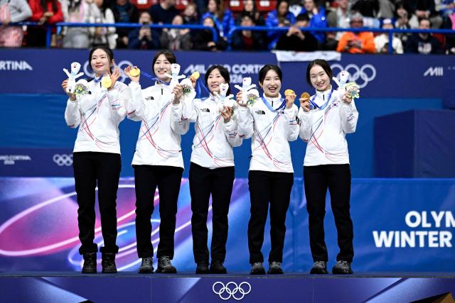 Team South Korea pose with their gold medals at the podium of the short track speed skating women's 3000m relay final during the Milano Cortina 2026 Winter Olympic Games at Milano Ice Skating Arena in Milan on February 18, 2026. (Photo by WANG Zhao / AFP)