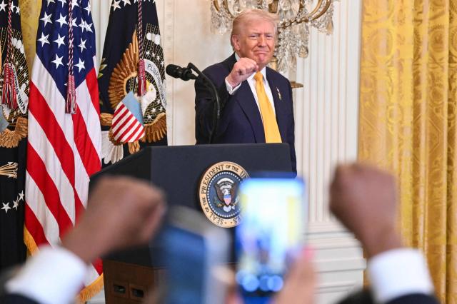 US President Donald Trump gestures to the audience as he departs after speaking during a Black History Month event in the East Room of the White House in Washington, DC, on February 18, 2026. (Photo by SAUL LOEB / AFP)