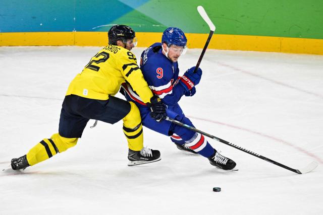 Sweden's #92 Gabriel Landeskog (L) fights for the puck with USA's #09 Jack Eichel during the men's play-off quarter-final ice hockey match between USA and Sweden at the Milano Santagiulia Ice Hockey Arena during the Milano Cortina 2026 Winter Olympic Games in Milan, on February 18, 2026. (Photo by Alexander NEMENOV / AFP)