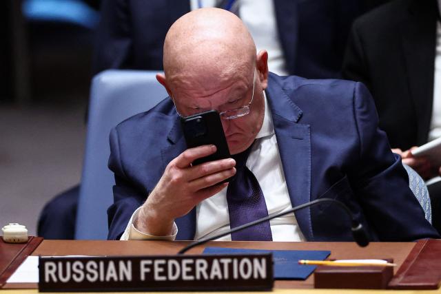 Russian Ambassador to the UN Vasily Nebenzya looks at his phone during a United Nations Security Council meeting on the Middle East at UN headquarters in New York on February 18, 2026. (Photo by CHARLY TRIBALLEAU / AFP)