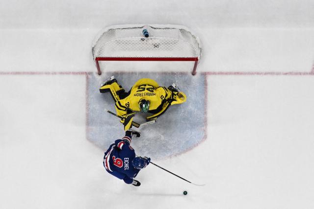 USA's #09 Jack Eichel controls the puck in front of Sweden's #25 Jacob Markstrom during the men's play-off quarter-final ice hockey match between USA and Sweden at the Milano Santagiulia Ice Hockey Arena during the Milano Cortina 2026 Winter Olympic Games in Milan, on February 18, 2026. (Photo by Alexander NEMENOV / AFP)