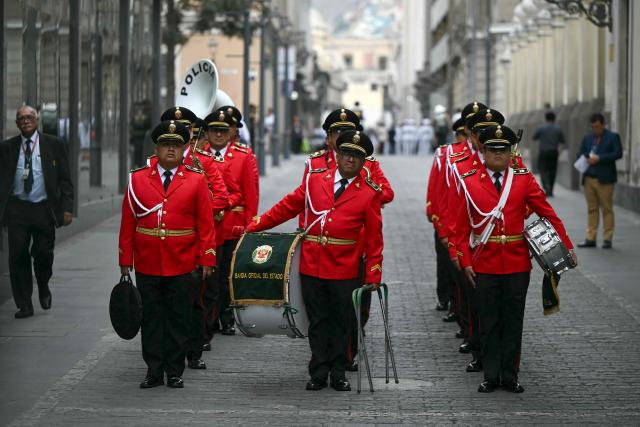 Band of the National Police of Peru members stand before the election of a new interim president outside the National Congress in Lima on February 18, 2026. Peru's Congress is set to name a new president, the country's eighth in a decade, on February 18, 2026, after Jose Jeri was impeached on graft allegations barely four months into his term. (Photo by Ernesto BENAVIDES / AFP)