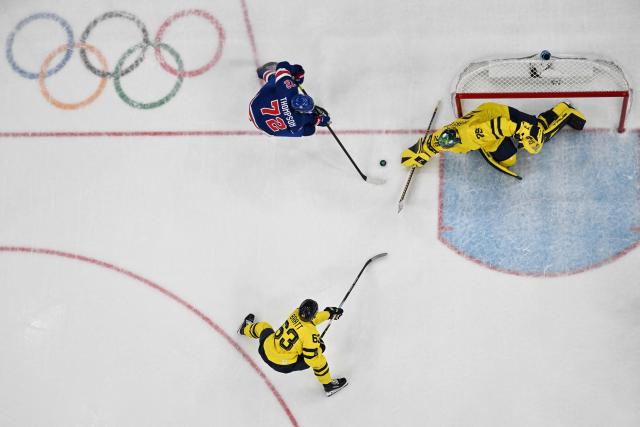 USA's #72 Tage Thompson (L) fights for the puck with Sweden's #25 Jacob Markstrom and Sweden's #63 Jesper Bratt during the men's play-off quarter-final ice hockey match between USA and Sweden at the Milano Santagiulia Ice Hockey Arena during the Milano Cortina 2026 Winter Olympic Games in Milan, on February 18, 2026. (Photo by Alexander NEMENOV / AFP)