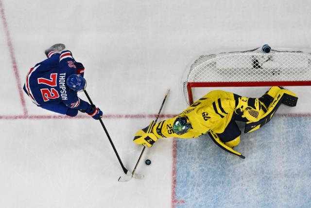 USA's #72 Tage Thompson (L) fights for the puck with Sweden's #25 Jacob Markstrom during the men's play-off quarter-final ice hockey match between USA and Sweden at the Milano Santagiulia Ice Hockey Arena during the Milano Cortina 2026 Winter Olympic Games in Milan, on February 18, 2026. (Photo by Alexander NEMENOV / AFP)