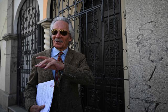 Guatemalan journalist and founder of the former newspaper El Periodico, Jose Ruben Zamora waves after present a memorandum at the headquarters of the Registry of Legal Entities of the Ministry of the Interior in Guatemala City on February 18,2026. The renowned Guatemalan journalist Jose Ruben Zamora, under house arrest, requested on February 18, 2026, the dissolution of a far-right foundation that he accuses of “criminalizing” and “persecuting” colleagues and human rights defenders. (Photo by JOHAN ORDONEZ / AFP)