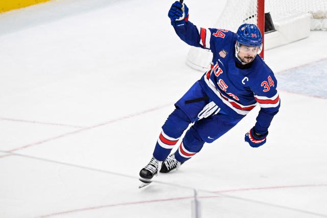 USA's #34 Auston Matthews celebrates after his team's second goal scored by USA's #43 Quinn Hughes at the end of the men's play-off quarter-final ice hockey match between USA and Sweden at the Milano Santagiulia Ice Hockey Arena during the Milano Cortina 2026 Winter Olympic Games in Milan, on February 18, 2026. USA wins 2 - 1 against Sweden and qualifies for the semi-finals. (Photo by Alexander NEMENOV / POOL / AFP)