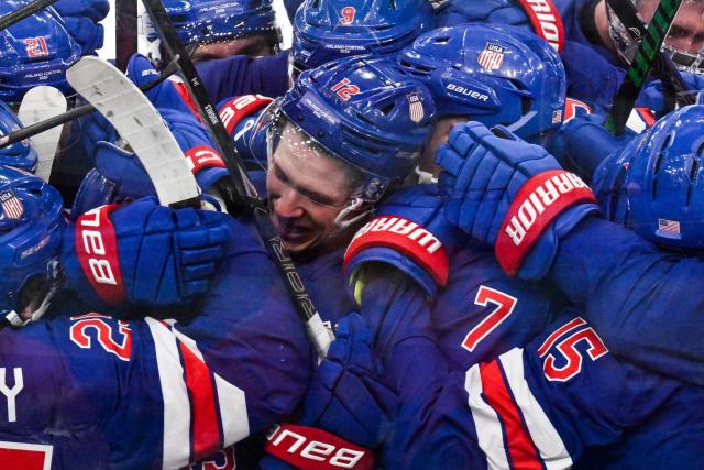 USA's team players celebrate after their team's second goal scored by USA's #43 Quinn Hughes at the end of the men's play-off quarter-final ice hockey match between USA and Sweden at the Milano Santagiulia Ice Hockey Arena during the Milano Cortina 2026 Winter Olympic Games in Milan, on February 18, 2026. USA wins 2 - 1 against Sweden and qualifies for the semi-finals. (Photo by Alexander NEMENOV / POOL / AFP)