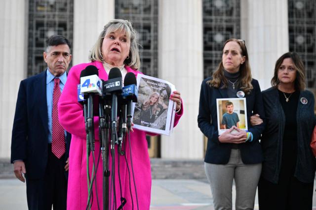 Lori Schott speaks while showing a picture of her daughter Annalee Schott who died by suicide after consuming social media content outside the Los Angeles Superior Court during the social media trial tasked to determine whether social media giants deliberately designed their platforms to be addictive to children, in Los Angeles, on February 18, 2026. (Photo by Frederic J. Brown / AFP)