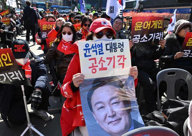 Supporters of South Korea's impeached former president Yoon Suk Yeol gather in front of the Seoul Central District Court in Seoul on February 19, 2026. A South Korean court will rule on February 19, on insurrection charges against ex-president Yoon Suk Yeol, weighing whether he should be sentenced to death for his failed bid to impose military rule. (Photo by Jung Yeon-je / AFP)