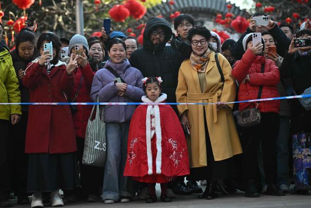 People gather to watch the recreation of a sacrifice ceremony at Ditan Park, or the Altar of the Earth, on the third day of the Lunar New Year of the Horse in Beijing on February 19, 2026. (Photo by Pedro PARDO / AFP)