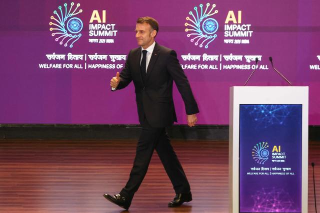 France's President Emmanuel Macron walks on the stage during the AI Impact Summit in New Delhi on February 19, 2026. (Photo by Ludovic MARIN / AFP)